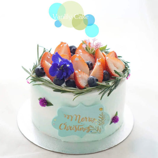 Vanlily Cake 鮮果米蛋糕,展示純白簡約的抹面,頂部裝飾有新鮮草莓、藍莓等時令水果,並點綴綠色香草葉,展現清新自然的視覺美感與手工質感。