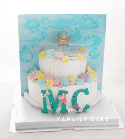  Vanlily Cake 半歲生日 1/2 造型蛋糕，白色奶油底搭配粉嫩花朵與「MC」縮寫，6個月成長慶祝推薦。