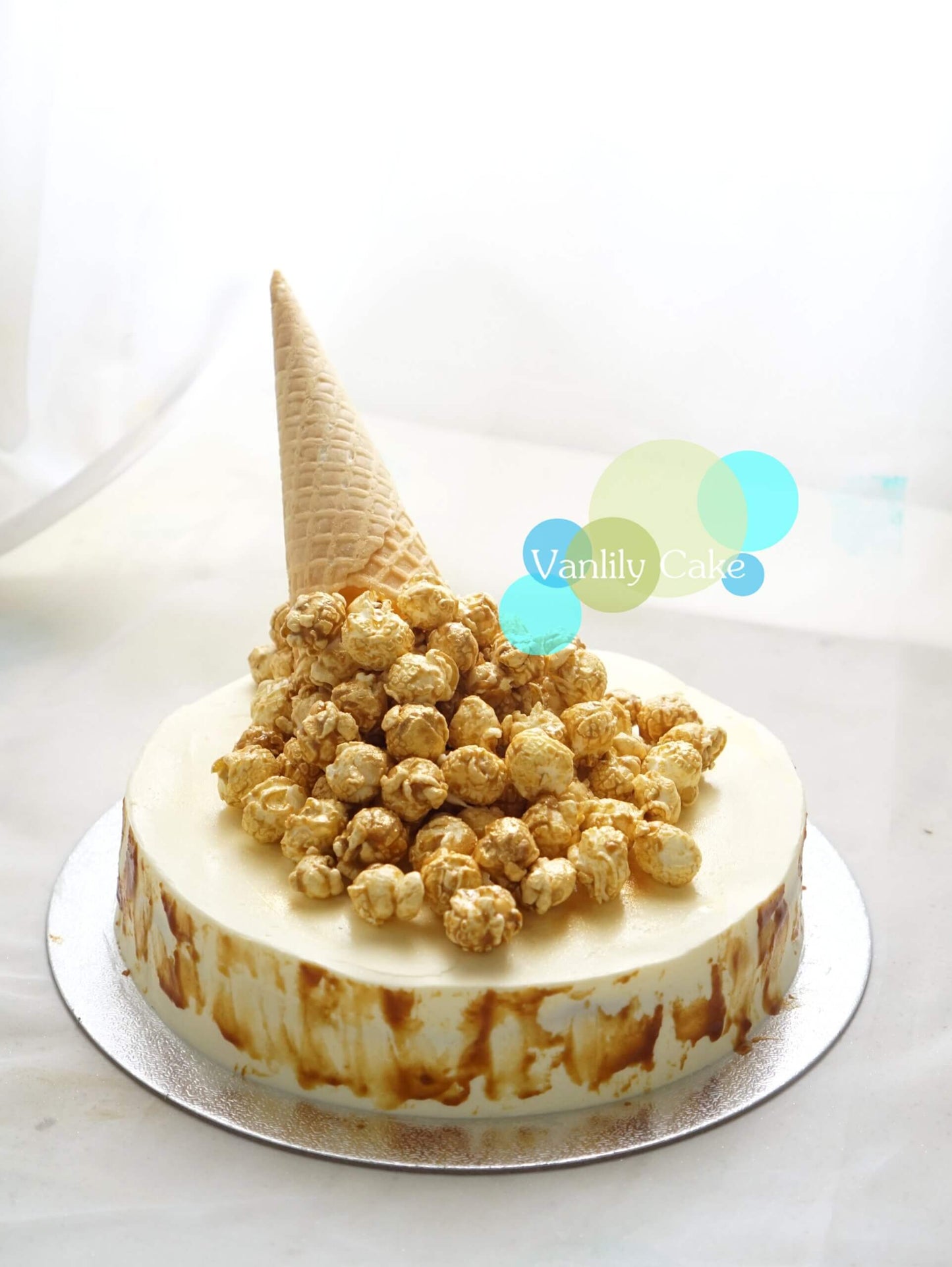 Vanlily Cake 海鹽焦糖流心芝士蛋糕，展示切開後濃郁焦糖醬流出的驚喜瞬間，頂部裝飾有焦糖爆谷與傾倒的威化筒造型，