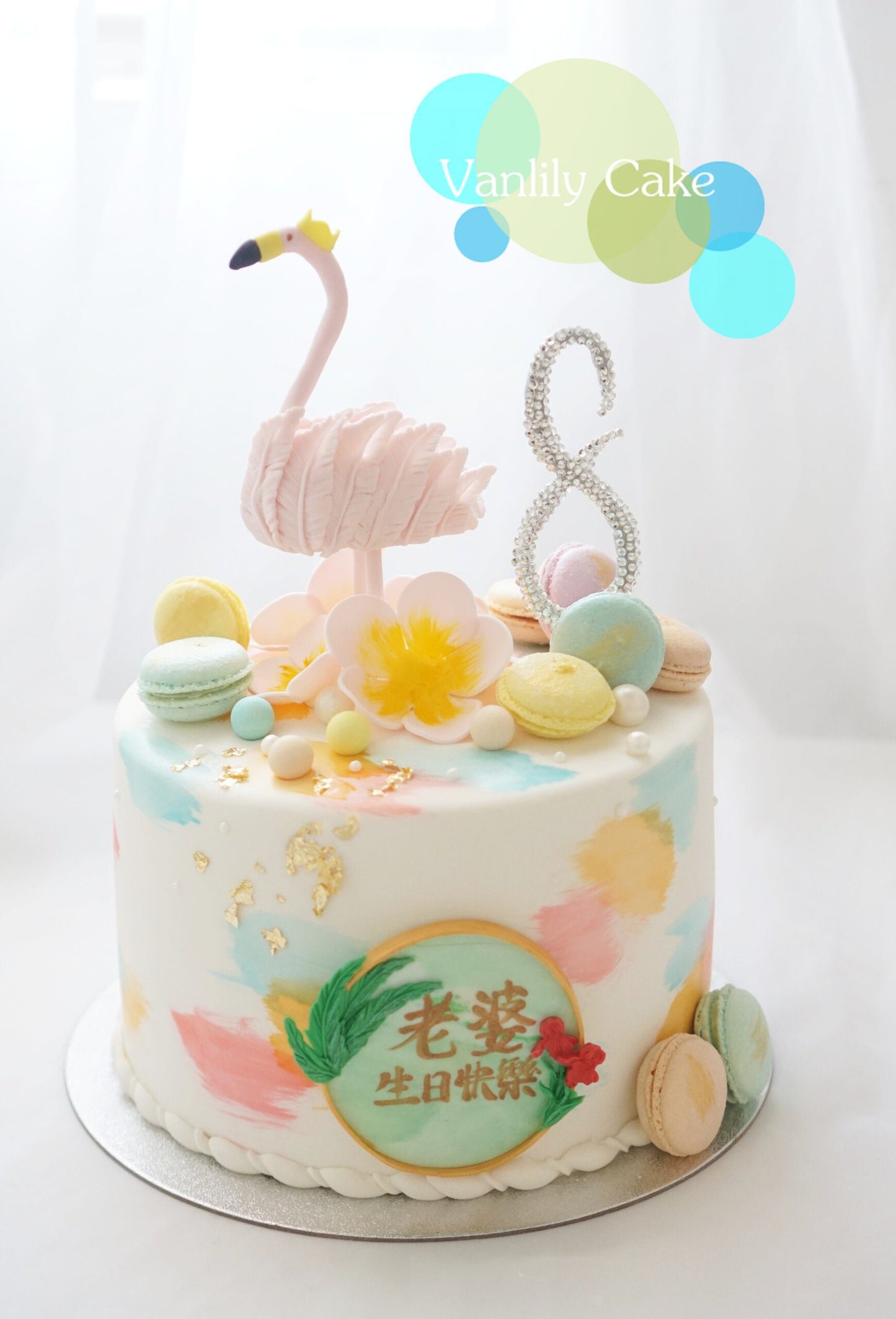 Vanlily Cake 火烈鳥Flamingo主題造型蛋糕，白色基底飾有繽紛手繪彩塊，頂端裝飾立體粉紅火烈鳥、繽紛馬卡龍與閃亮數字，充滿藝術氣息。
