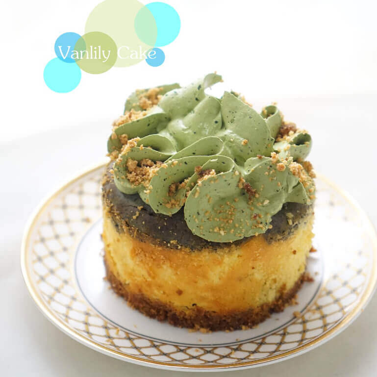 Vanlily Cake 栗子南瓜芝麻芝士蛋糕，展示精緻的三層結構：黃色南瓜芝士底層、深色黑芝麻中層，頂部裝飾有淡綠色波浪狀忌廉與栗子碎，呈現高雅的和風養生質感。