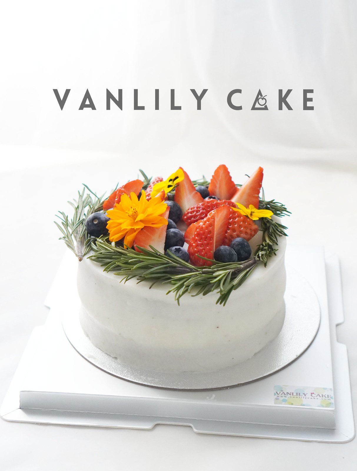 Vanlily Cake 純素香蕉生日蛋糕，展示淮山（白色外層）與蕃薯南瓜（黃色外層）兩款選擇，裝飾有新鮮水果、藍莓與迷迭香，適合一歲寶寶、素食與過敏人士。